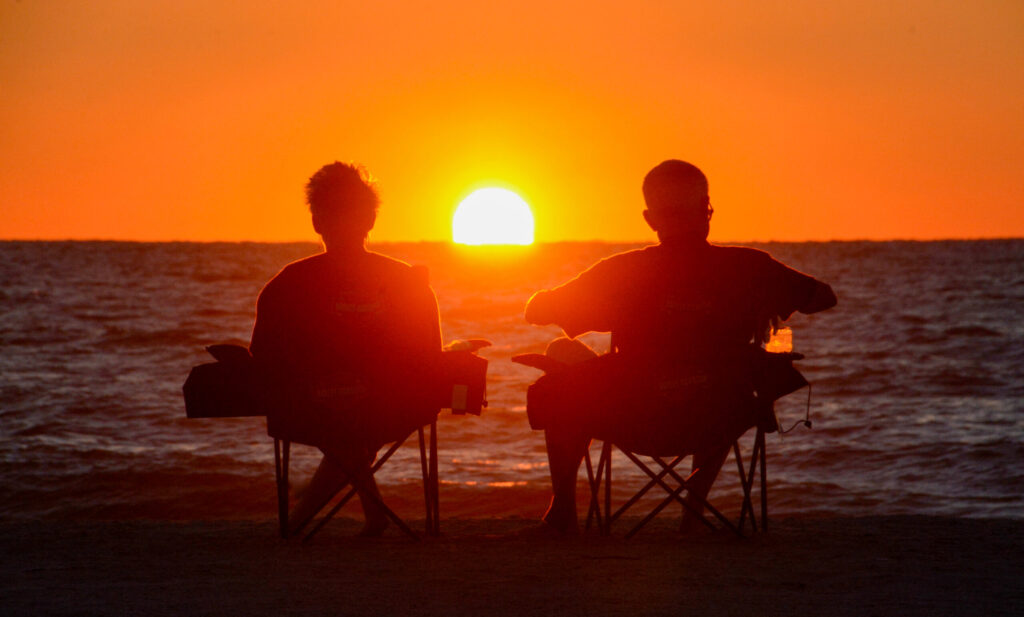 Clearwater-Beach-Strand-Sonnenuntergnag-Paar_Foto-Ralf-Johnen Mann und Frau sitzen am Strand von Clearwater in Florida beim Sonnenuntergang