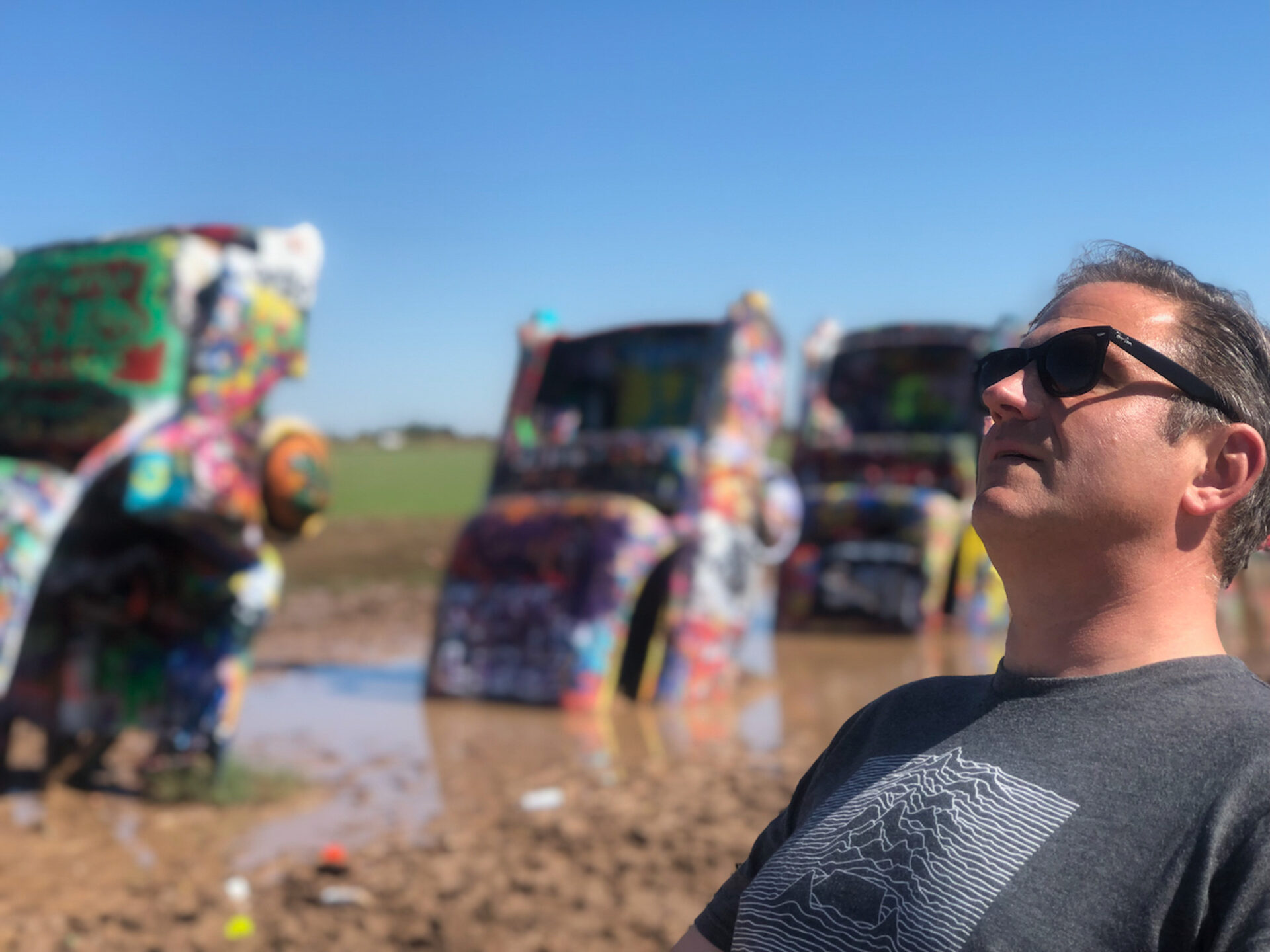 autor-in-schieflage-vor-autowracks-cadillac-ranch_foto-ralf-johnen Autor Ralf Johnen lehnt sich vor der Cadillac Ranch zurück