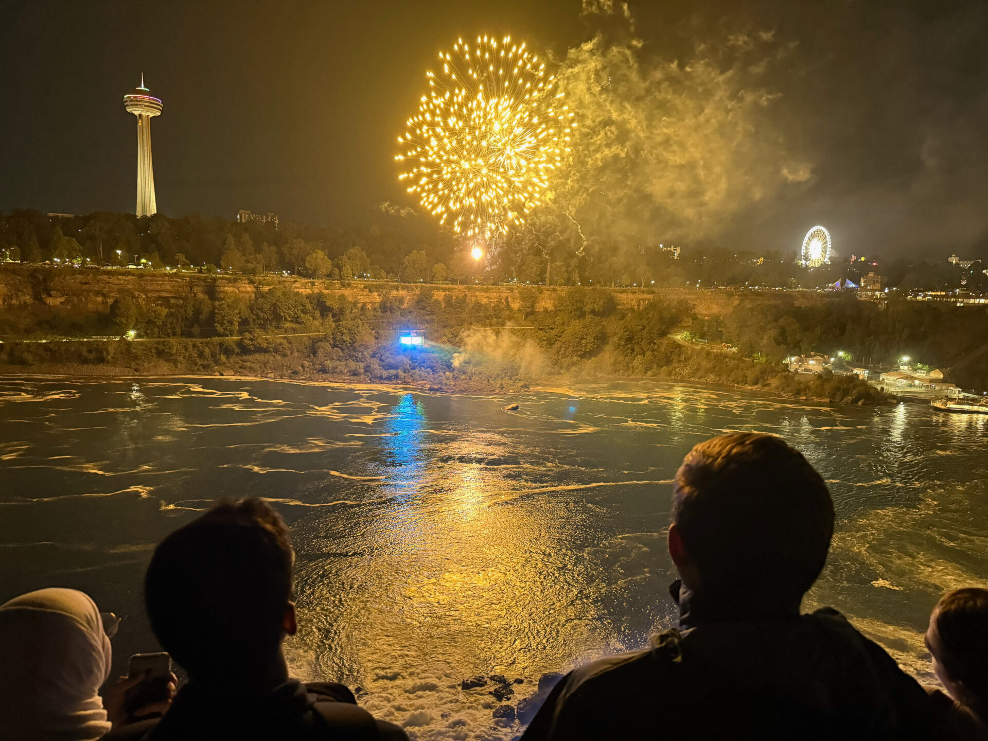 Besucher blicken bei Feuerwerk auf die Niagarafälle in Niagara Falls, New York