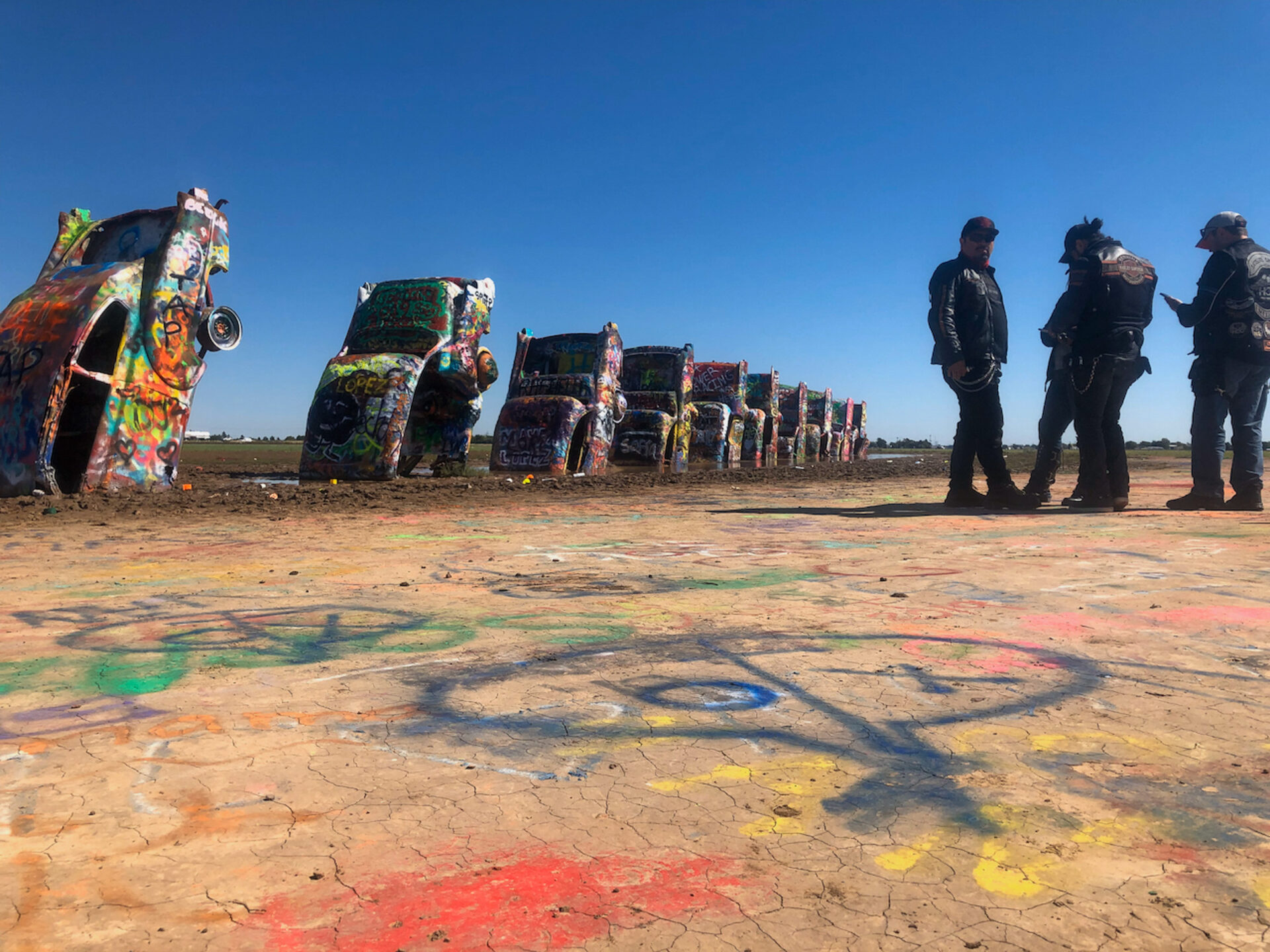 rockerbande-vor-autowracks-cadillac-ranch-amarillo_foto-ralf-johnen Männer in schwerer Ledermontur bewundern die Cadillac Ranch