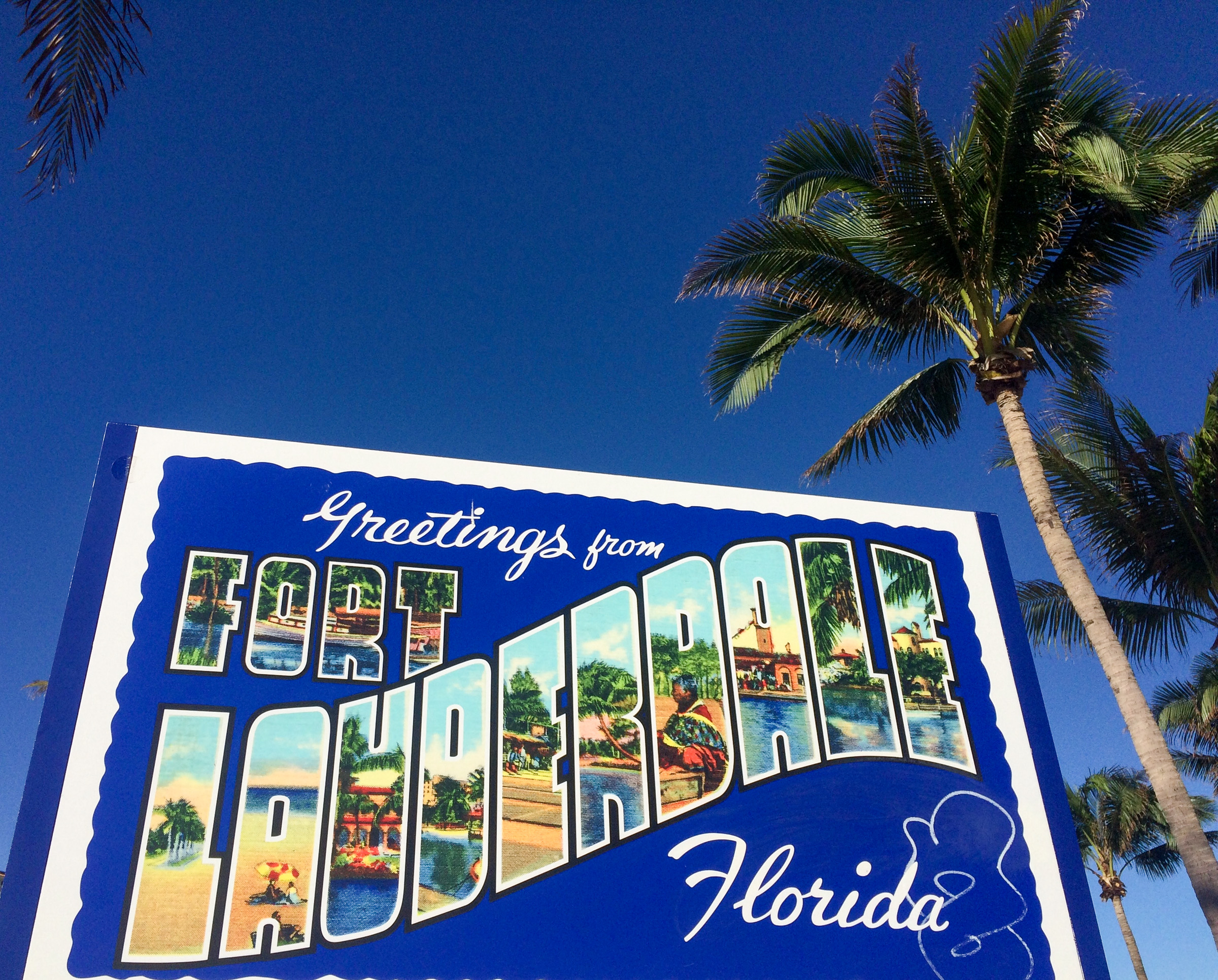 Werbeschild für Fort Lauderdale mit blauem Himmel und Palmen 