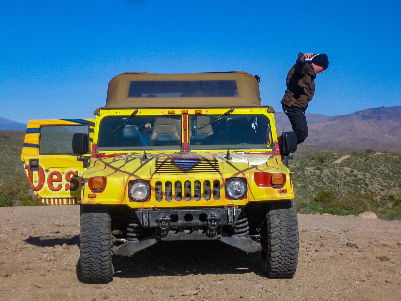 Mann springt aus einem Hummer bei einer Tour durch die Wüste Scottsdales