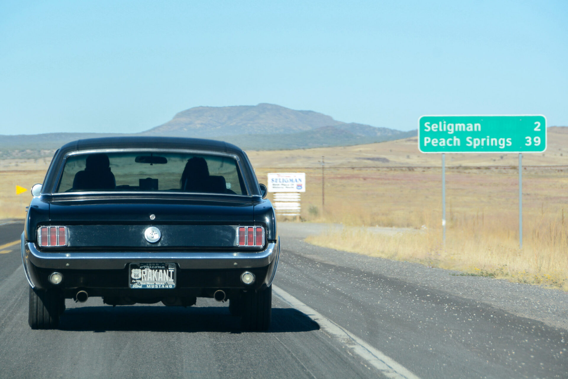 Ein schwarzer Ford Mustang fährt auf das Dorf Seligman in Arizona zu 