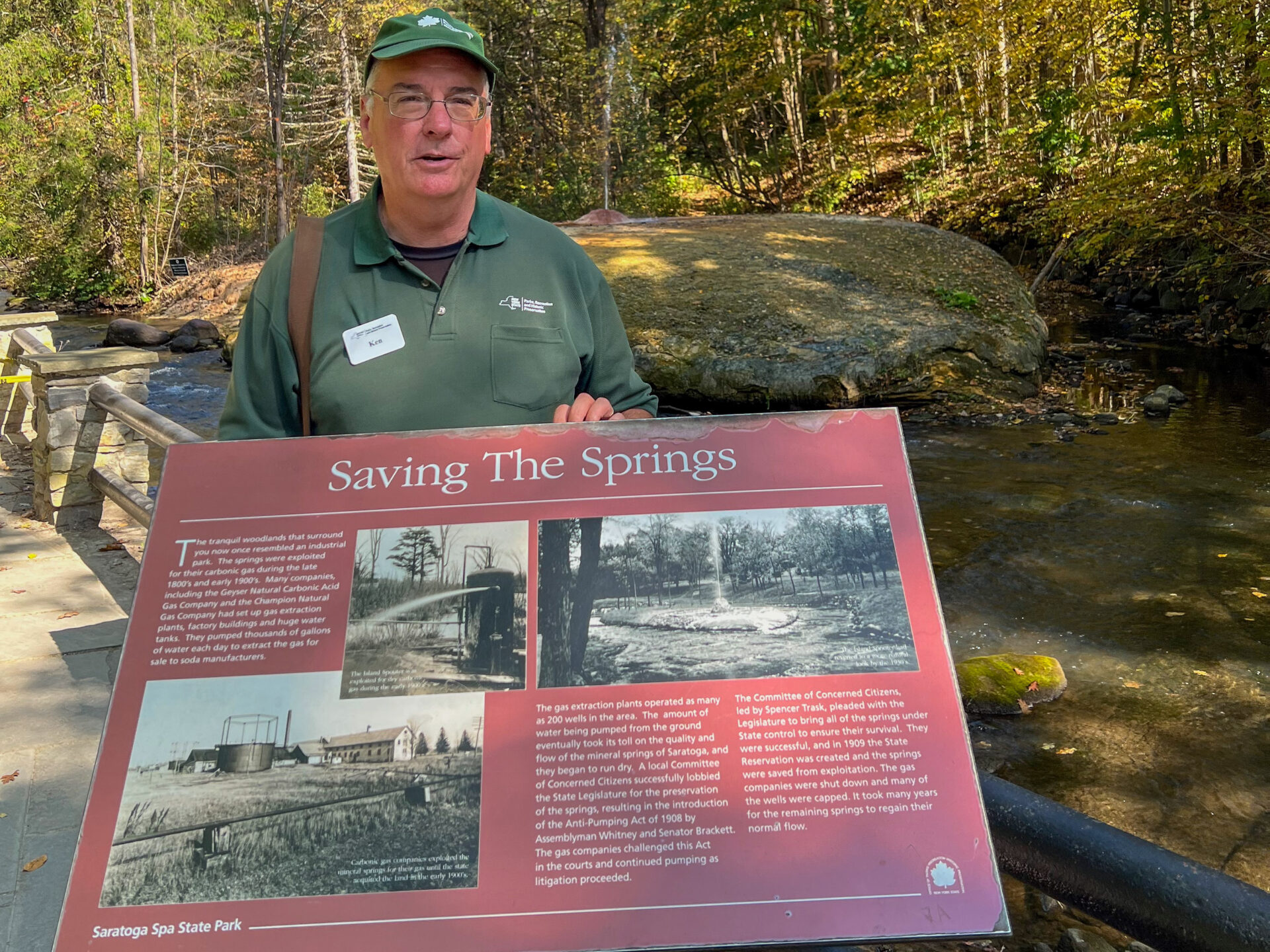 mann-schild-rettet-die-quellen-saratoga-springs-newyorkstate_foto-ralf-johnen Ein Touristenführer klärt hinter einen Schild darüber aus, wie die Quellen von Amerikas Mineralwasser in Saratoga Springs beinahe ausgetrocknet wären