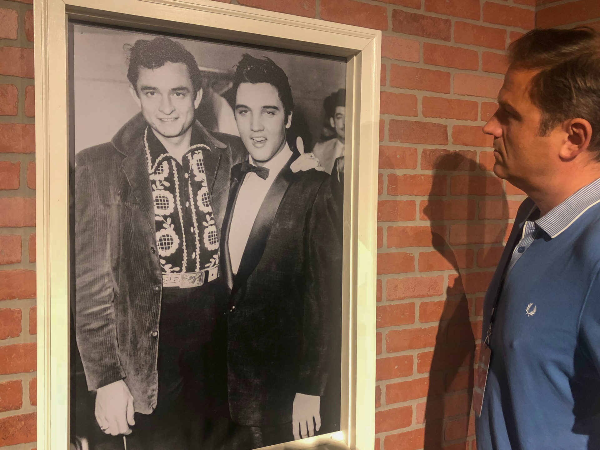 Autor Ralf vor einem Foto von Johnny Cash mit Elvis Presley beim Besuch von Graceland in Memphis
