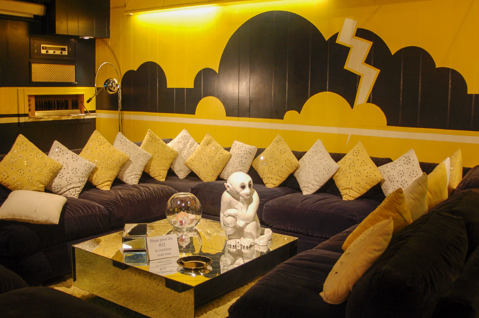 Ein gelb-schwarz eingerichteter Raum in Graceland mit einem Äffchen auf dem Tisch
