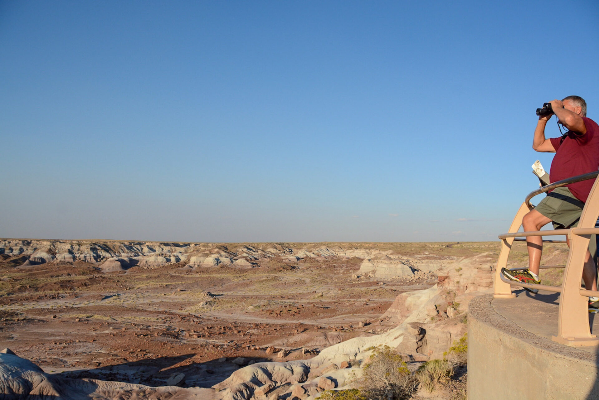 Mann mit Fernglas schaut in die Weiten des Nationalparks Painted Desert Petrified Forest im US-Bundesstaat Arizona