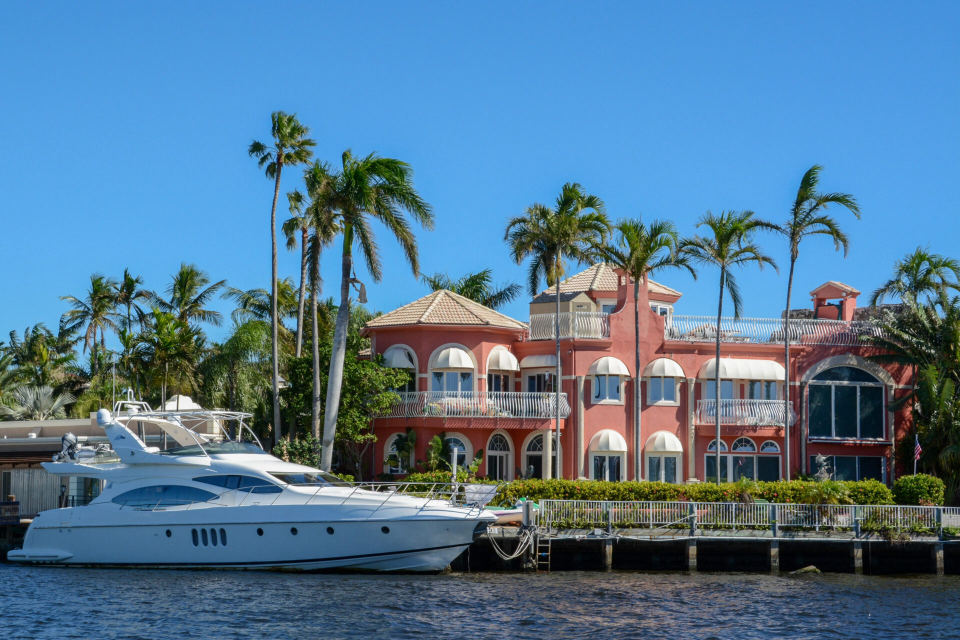 Millionärsvilla mit schnittigem Boot und palmengesäumtem Boot am Ufer eines Kanals in Fort Lauderdale in Florida